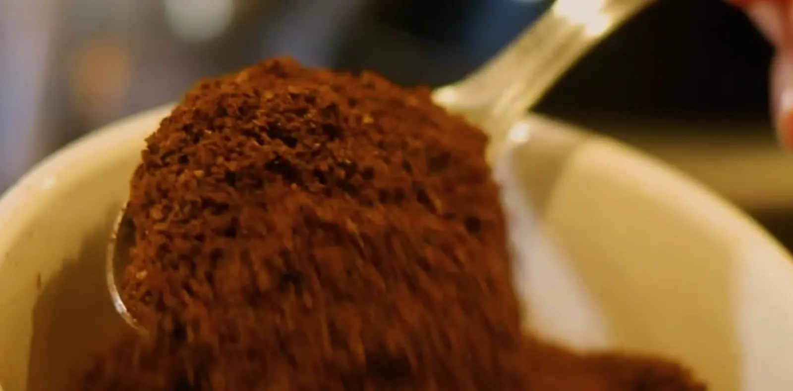 Café moído sendo dosado com uma colher